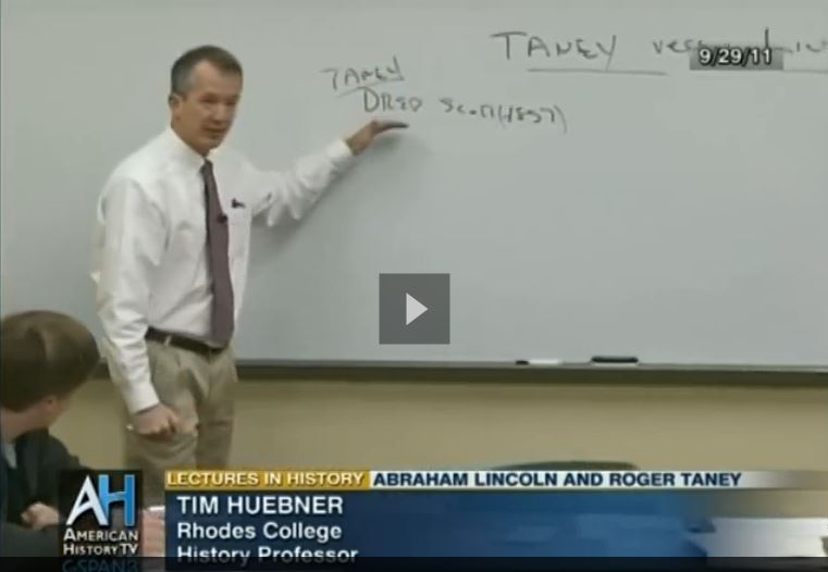 a professor in front of a white board