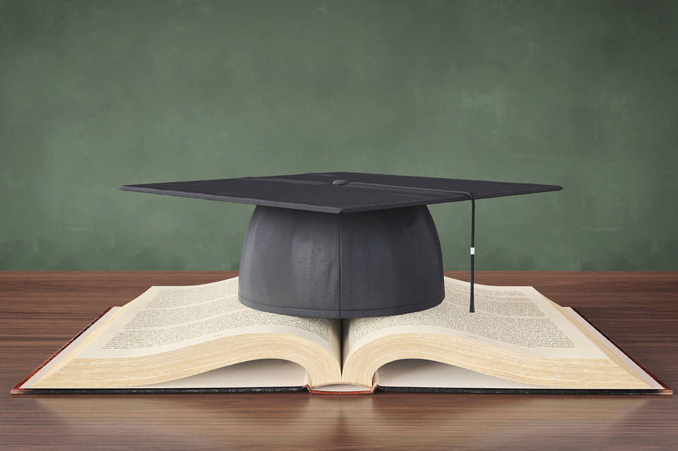 a college graduation cap sitting on a book