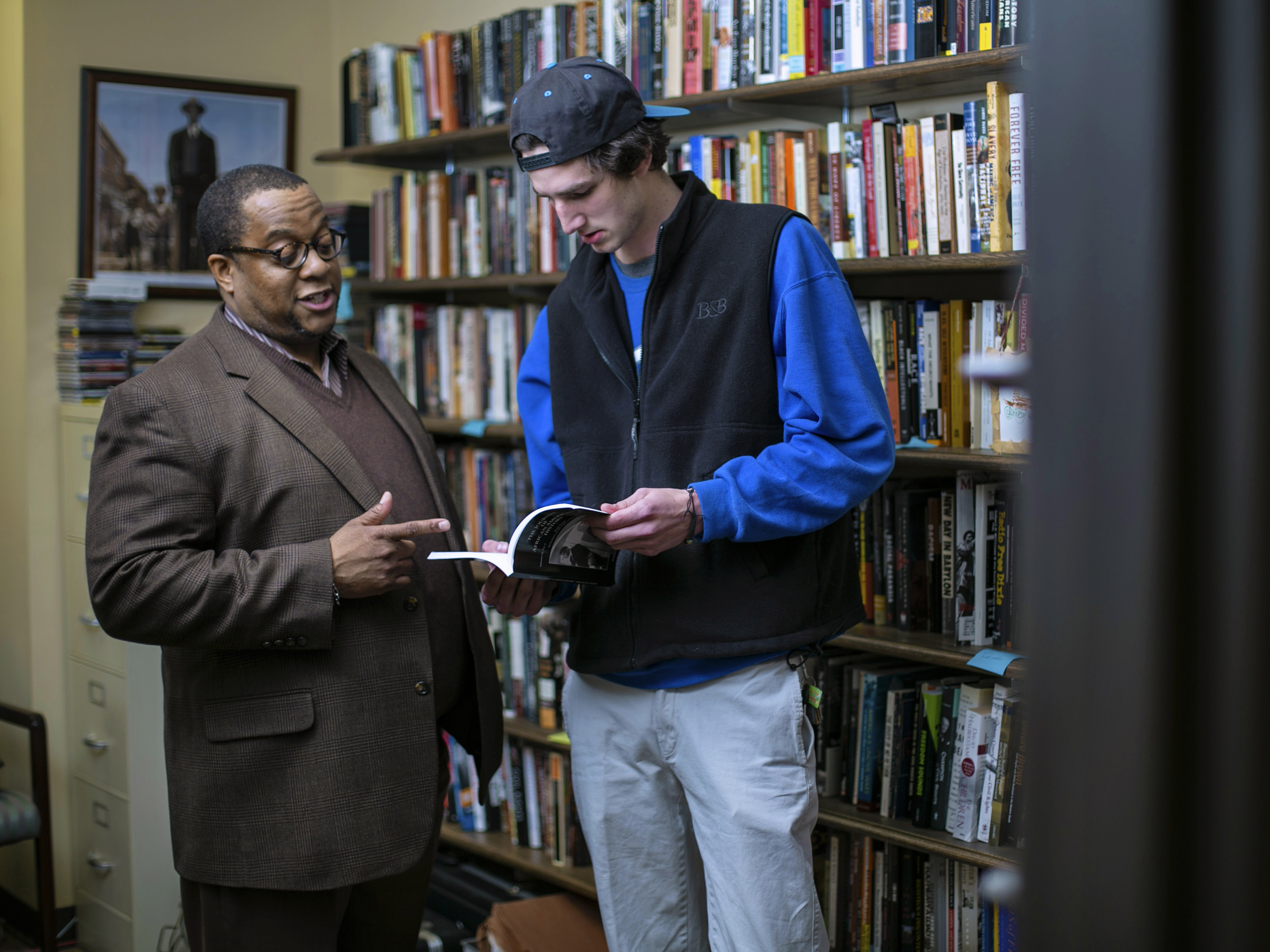 A professor reviews a text with a student.