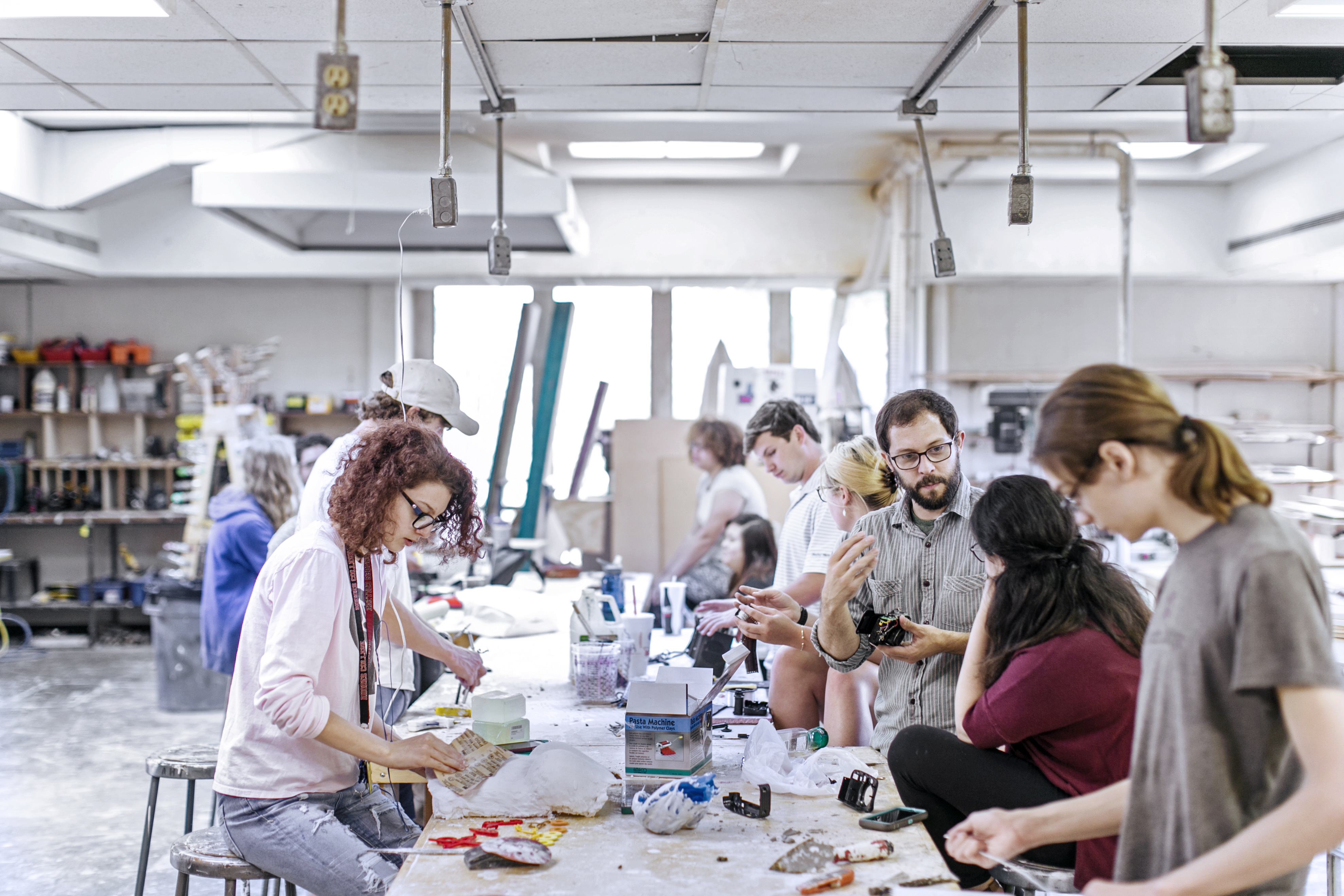 students gather around a table to do projects