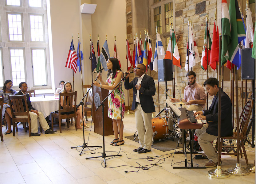 Students playing music in front of an assortment of flags