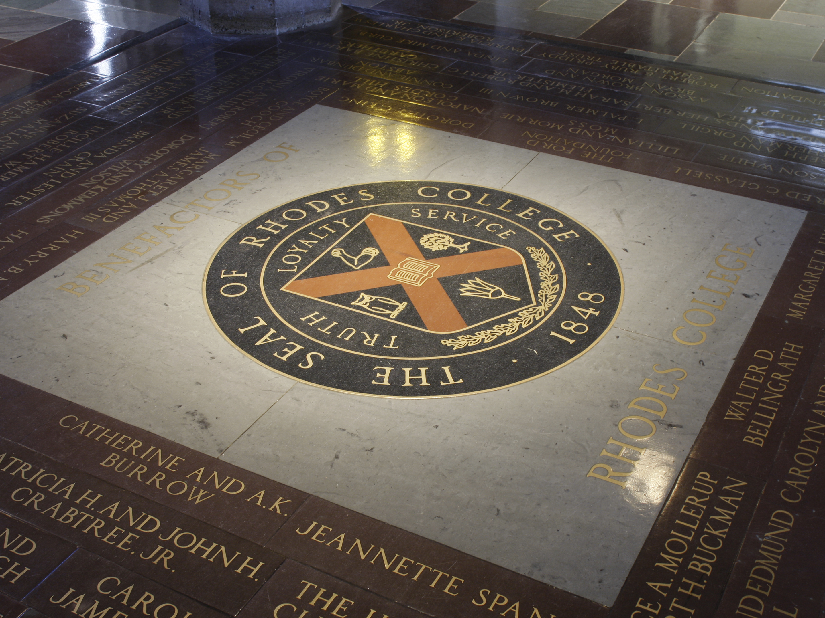 The seal of Rhodes College inlaid in the floor of Palmer Hall. If a student walk across it, the legend says that they will ever graduate