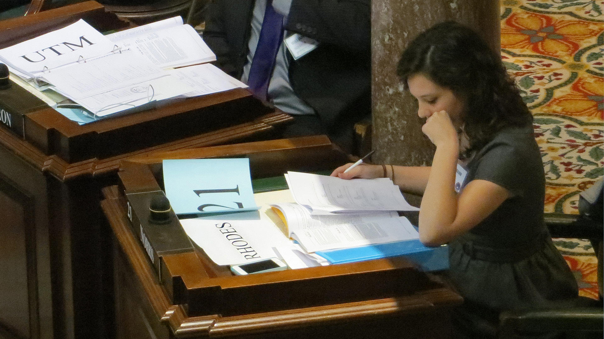a female student studies legislative papers at a desk