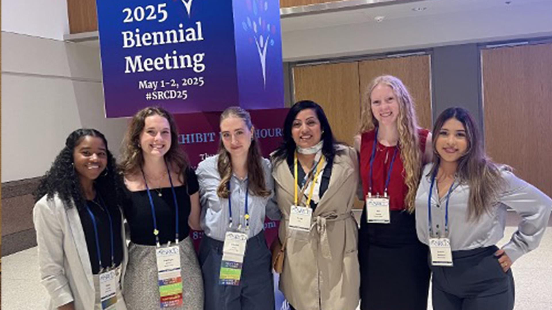 young women in front of a conference sign