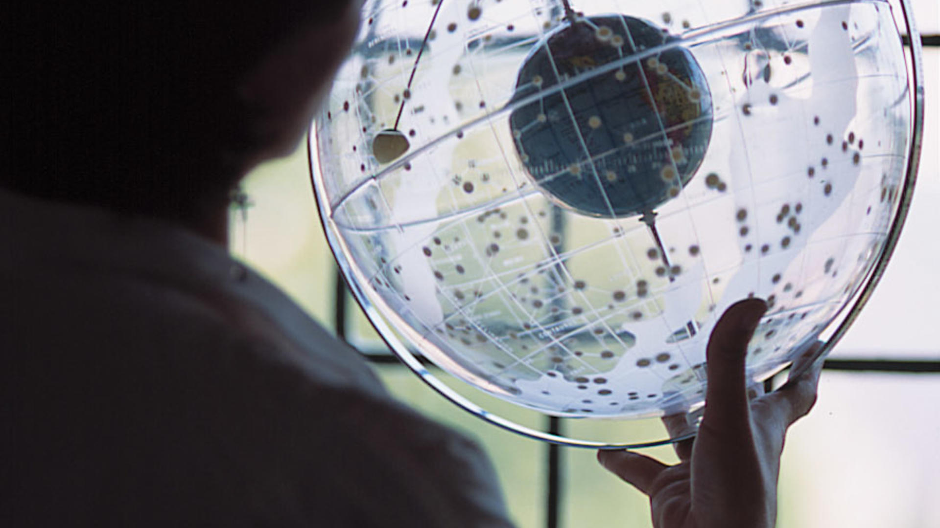 a student examining a clear globe