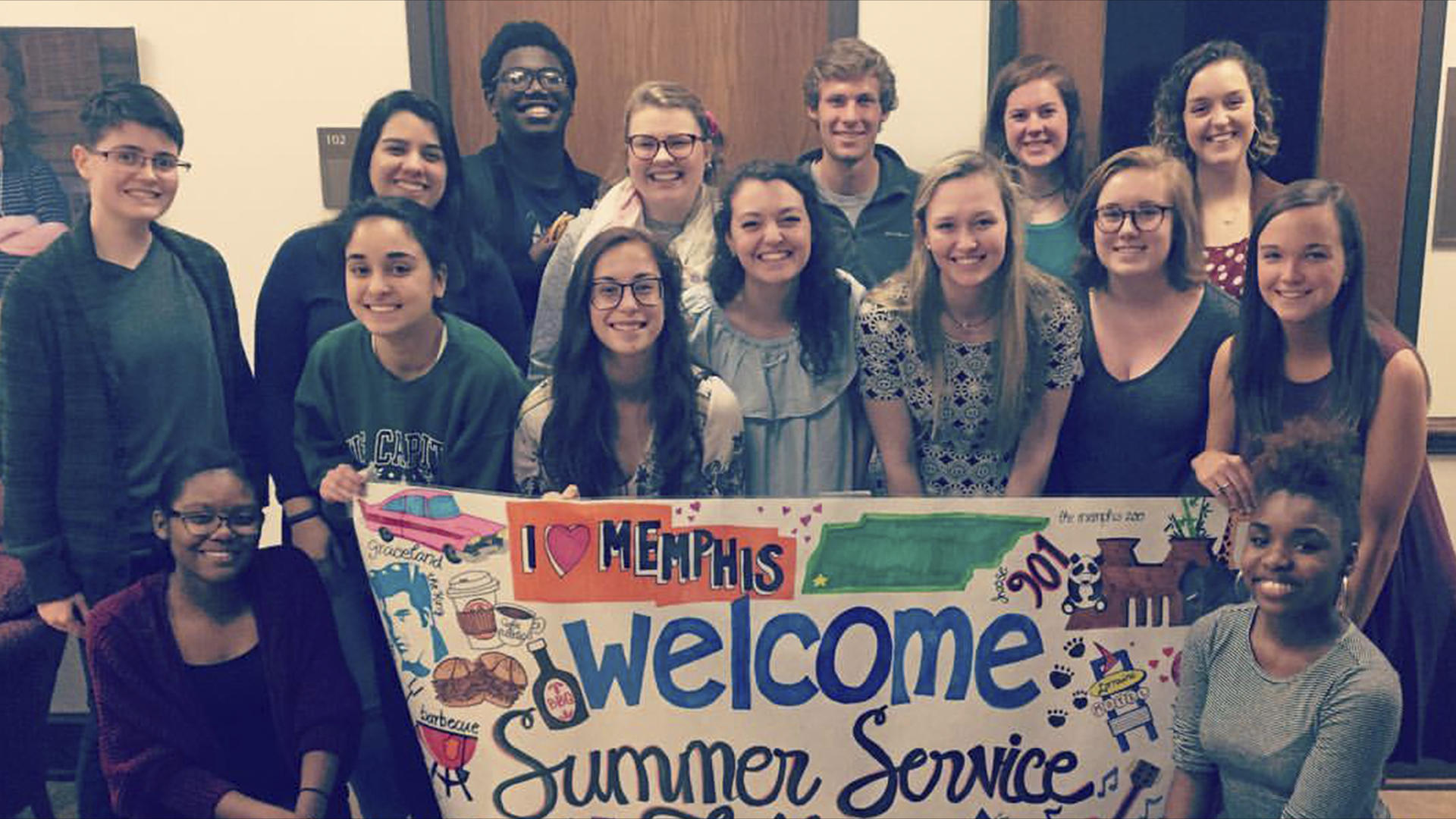 a group of students holding a welcome sign