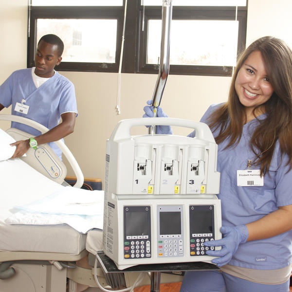 a student standing with a medical machine