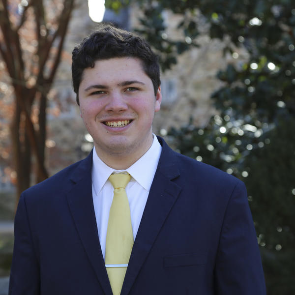 Portrait of Alex Schramkowski outside by a tree