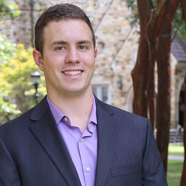 Portrait of Caleb Fowler in front of a Rhodes building surrounded by trees