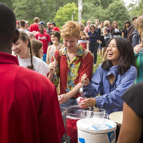 Laughing students spoon toppings onto their ice cream sundaes at one of the new student socials.