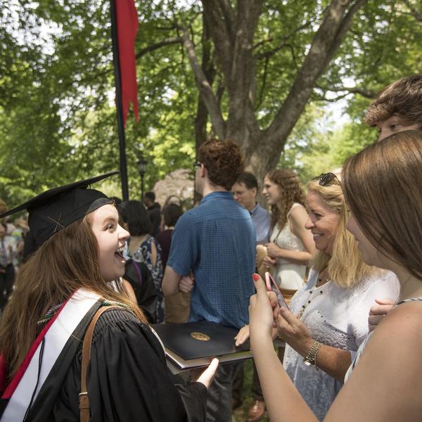 A family greets their graduate at commencement.