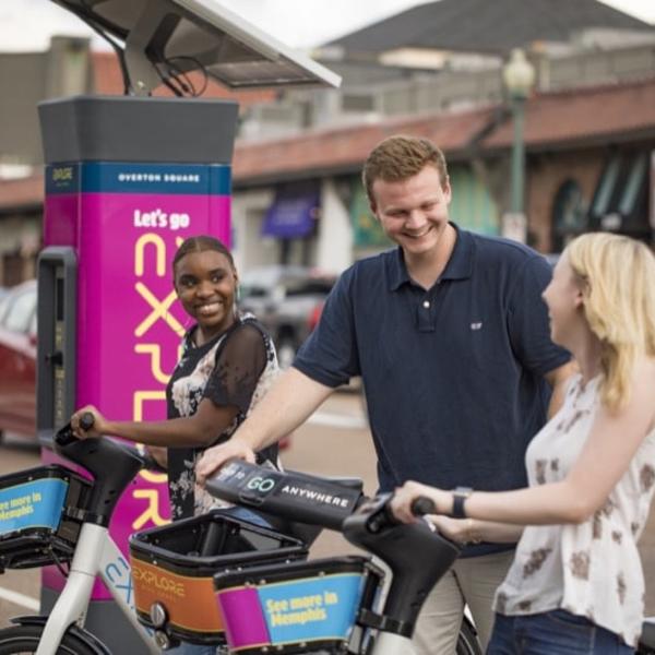 Two students rent bikes from a ridesharing station.
