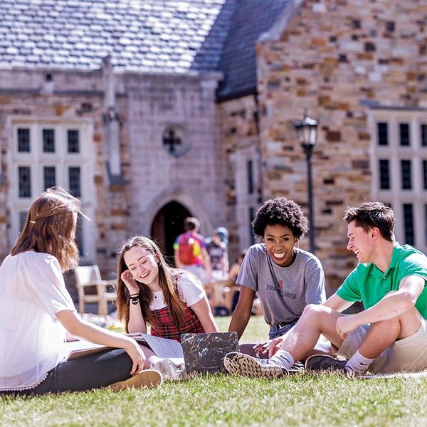 Students sitting on a grassy quad.