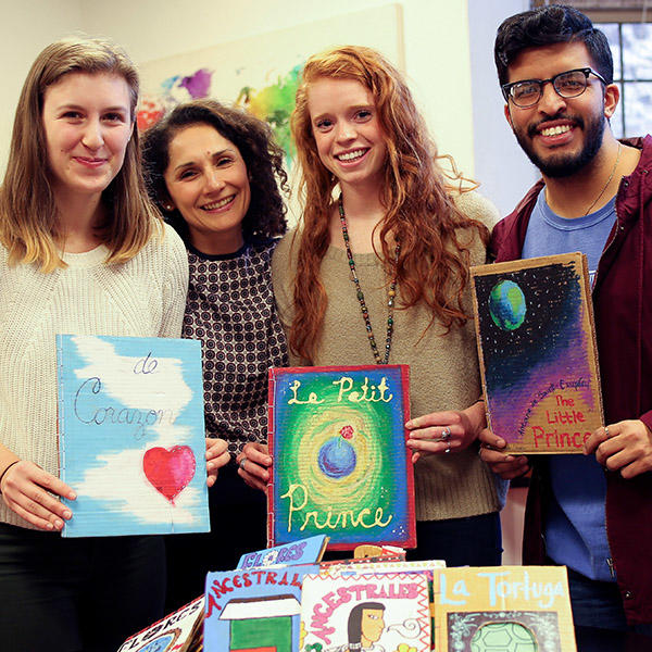 a professor and students hold up Spanish language books