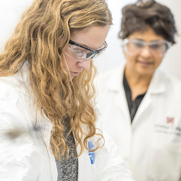 a student and professor in white lab coats