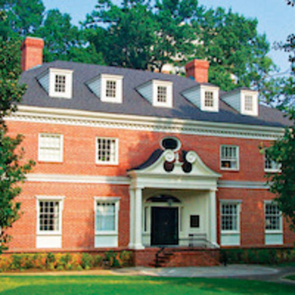 A red brick, three-story colonial style building with white trim.