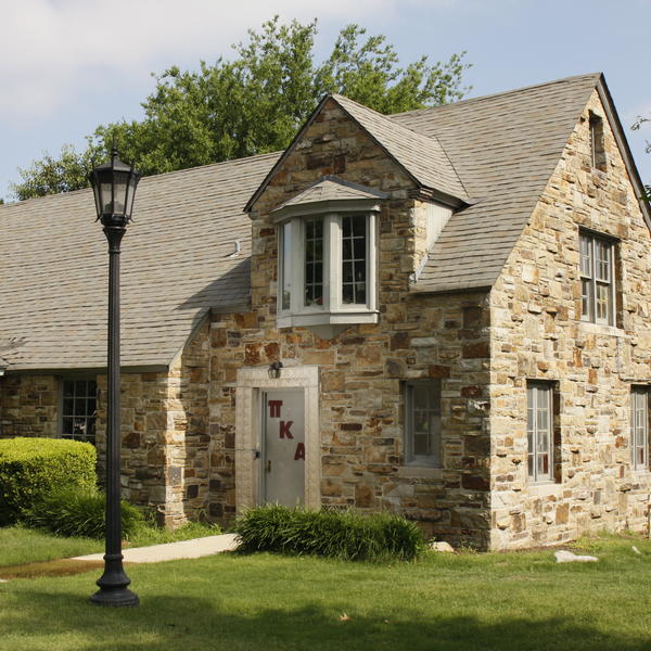 A stone house with a lamp post in front