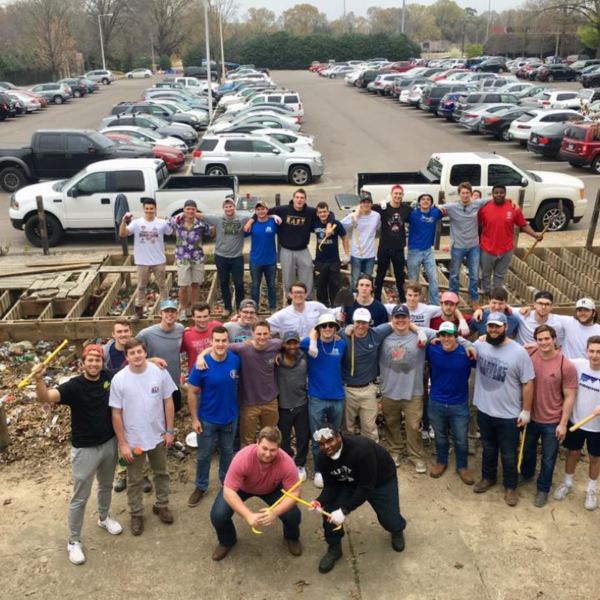 Men standing in front of a build site and parking lot