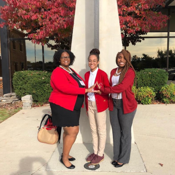 Three women in red cardigans in the outdoors