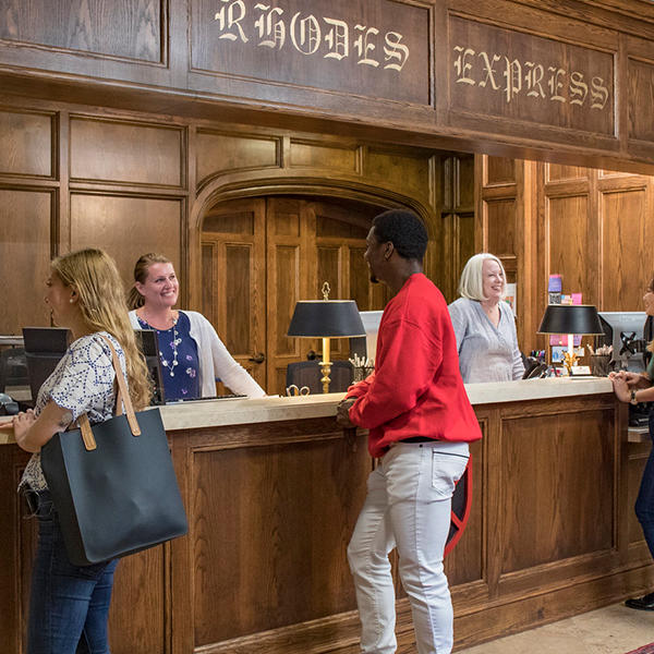 students being helped at a counter 