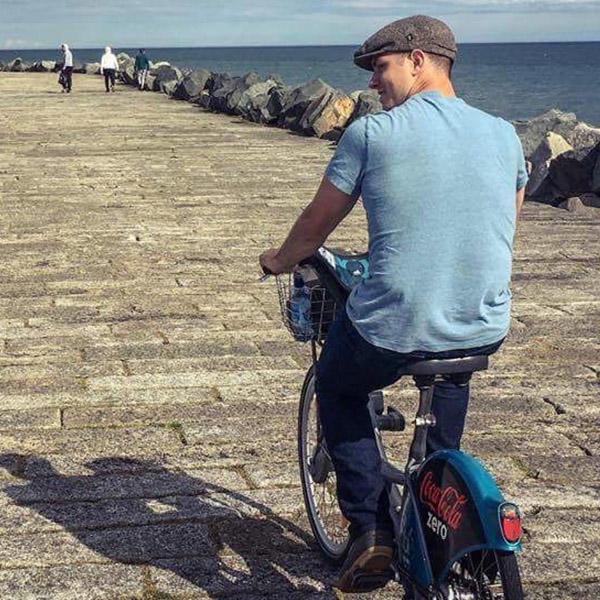 a young man bikes on a pier near the ocean