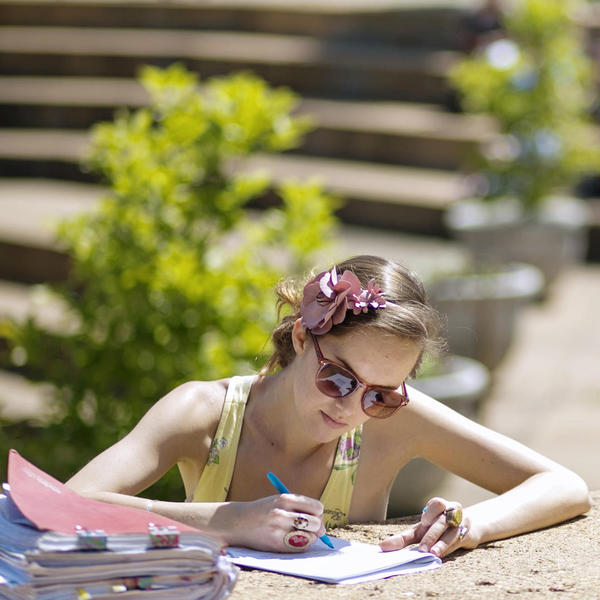 Young woman studying in the summer sun