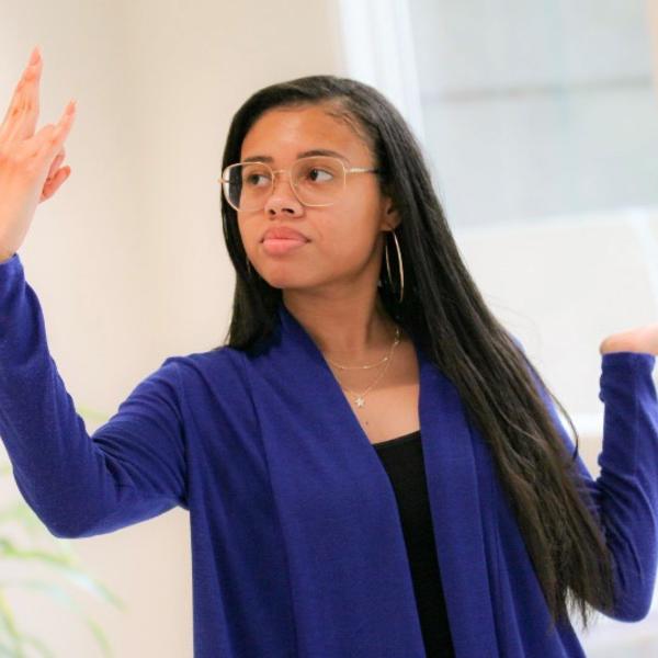 an African American young woman with uplifted arms