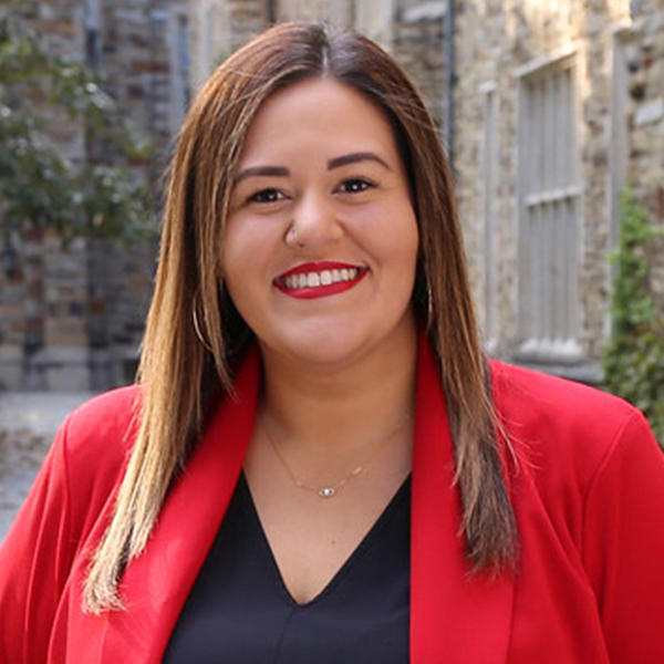 a woman with long brown hair in a red suit