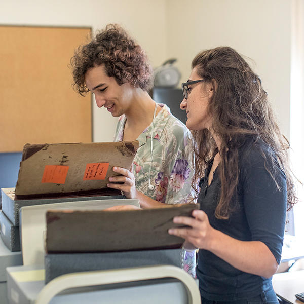 two students look over an old folio
