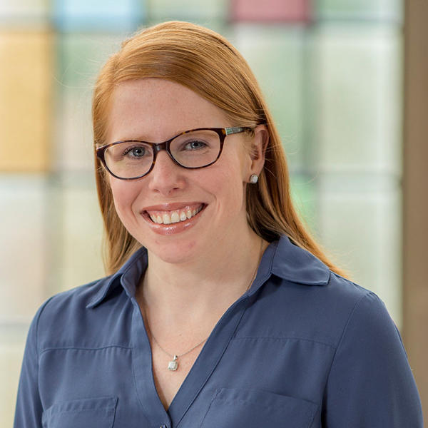 a woman with red hair and glasses