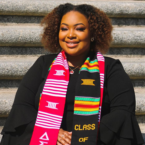 a young African American woman in graduation robes