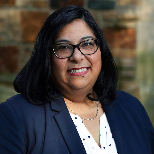 a woman with shoulder-length dark hair and glasses