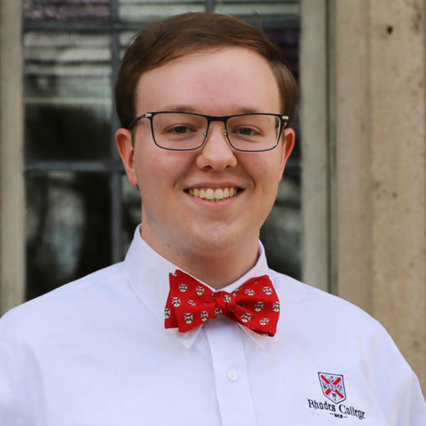 a young man with glasses and a Rhodes bowtie