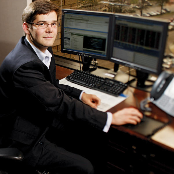 a young man sits at a computer desk