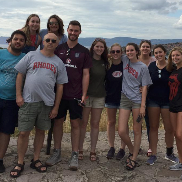 a group of students and a male professor on a hilltop in Greece