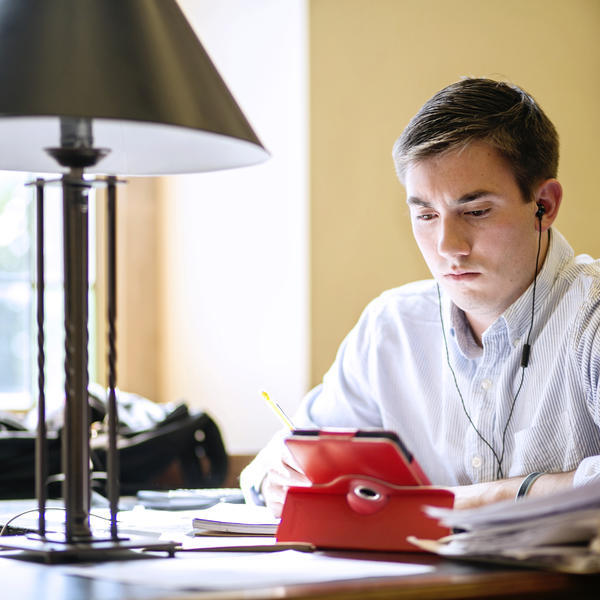 a young man studies with headphones