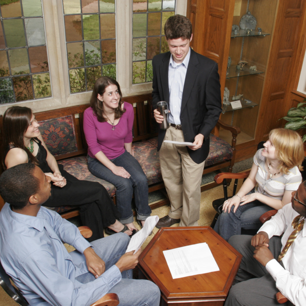 a group of students gather around a student speaking
