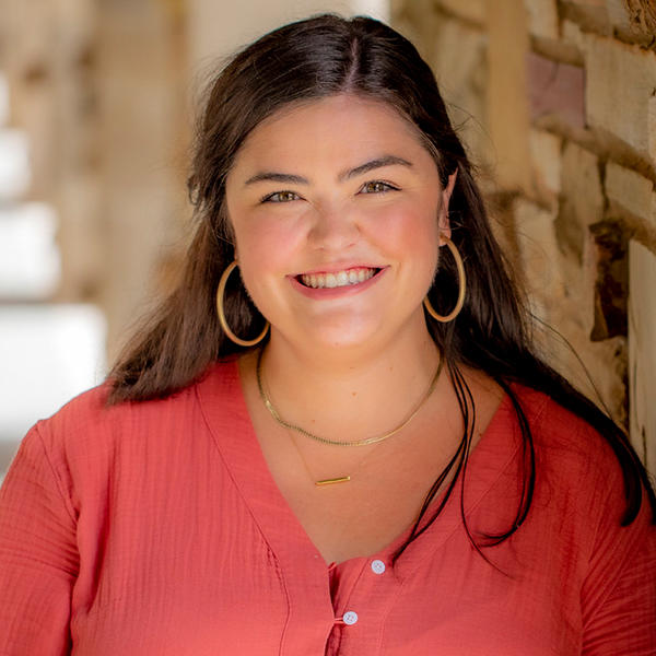 a young woman with long brown hair and hoop earrings