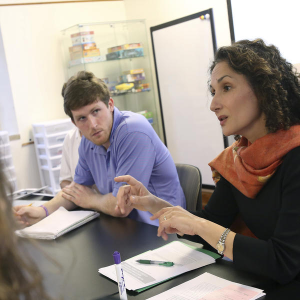 a female professor talks with a student in class