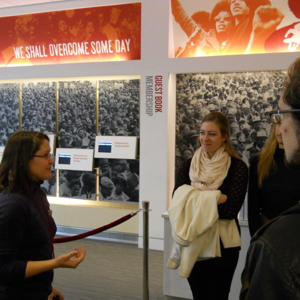 students listen to a tour leader at a museum
