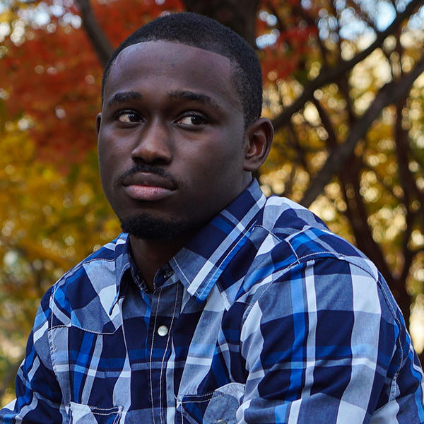 aa young African American man in a plaid shirt