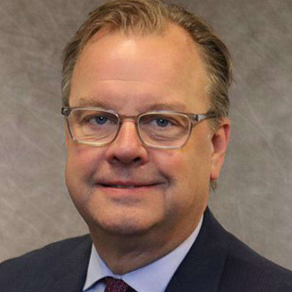 headshot of a  man with glasses looking at the camera