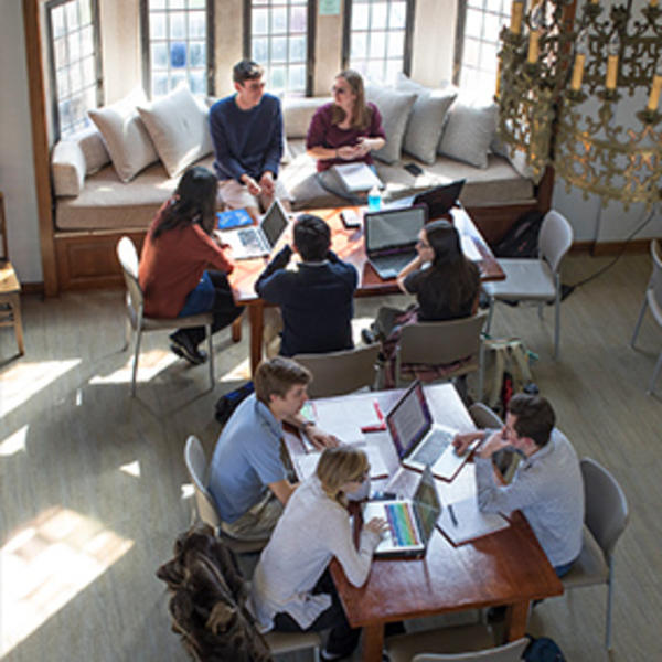 an overhead shot of students studying in a room with gothic windows