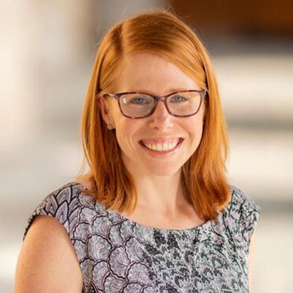 a woman with red hair and glasses