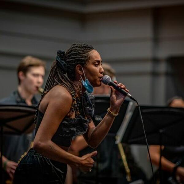 A woman singing in front of a band.