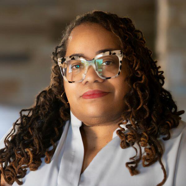 a woman with curly hair and glasses