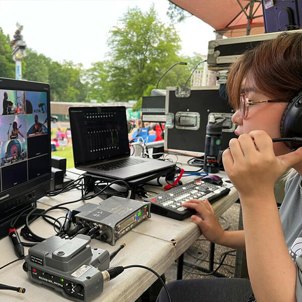 a young  woman looks at a monitor backstage