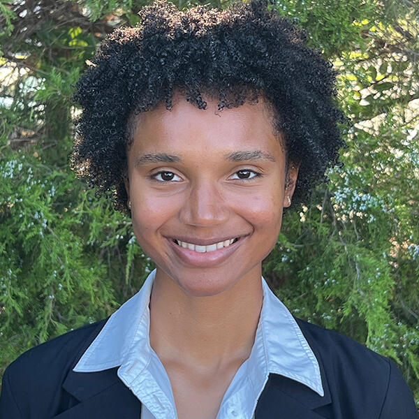 a young African American woman dressed in blue smiles at the camera