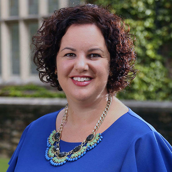 a woman with short curly hair in a blue dress 