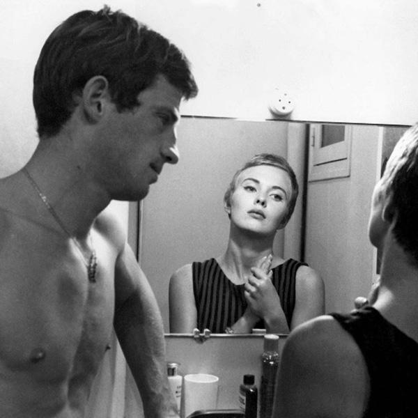a man gazes at a woman looking in a mirror